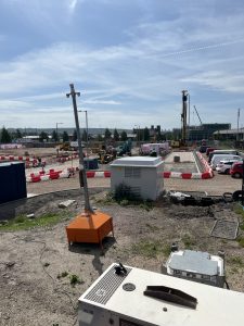 Active UK residential construction site with groundworks and site cabins needing day-one internet connectivity