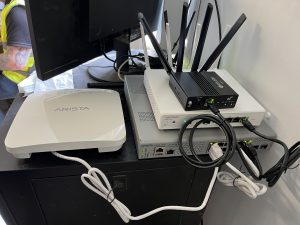Arista VeloCloud SD-WAN edge, Arista PoE switch, Arista Wi-Fi access point and 5G router installed in a construction site office